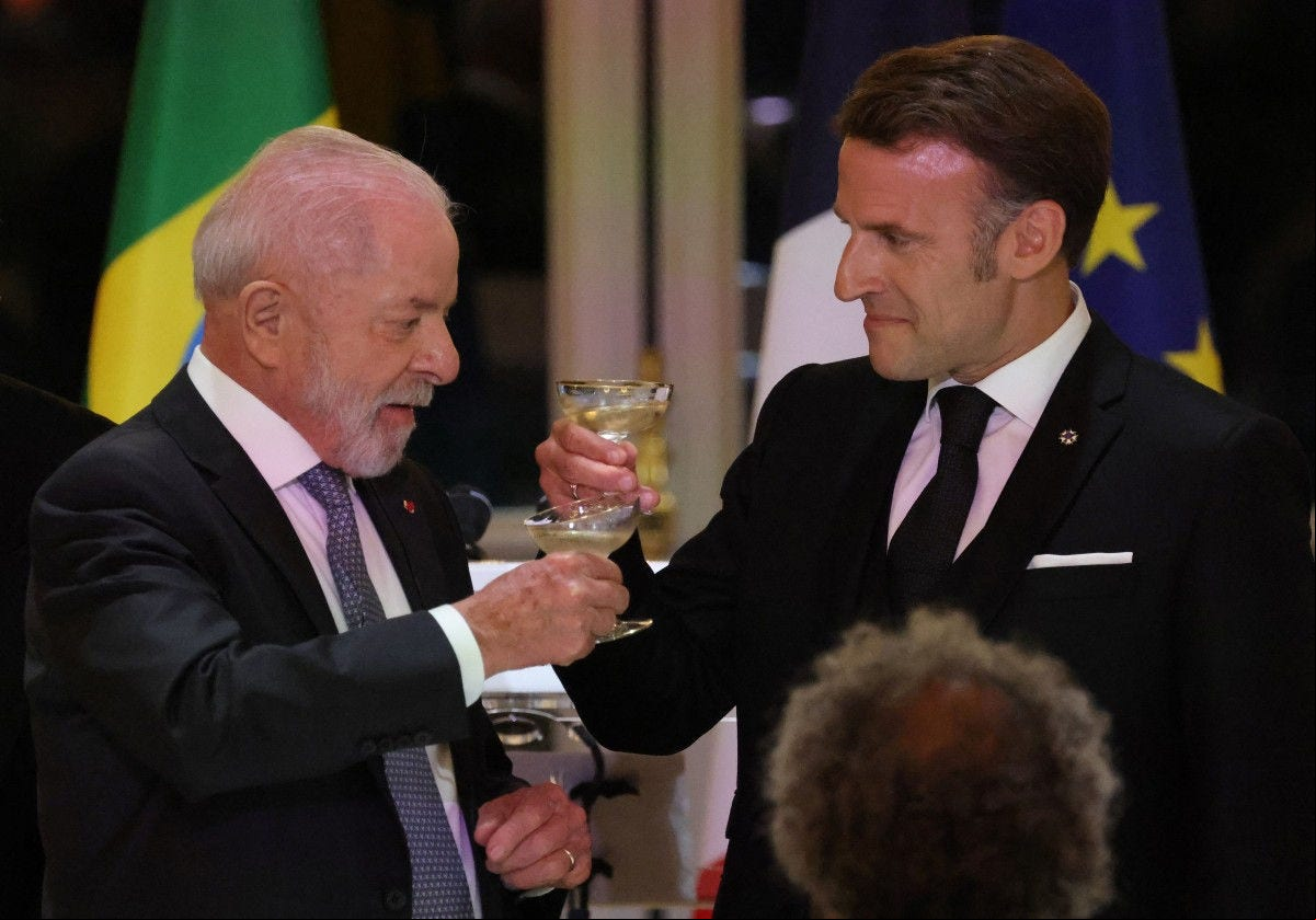 Brazil's President Luiz Inacio Lula da Silva (L) and 's President Emmanuel Macron raise their glasses during a state dinner at the presidential Elysee Palace in Paris on June 5, 2025. (Photo by Ludovic MARIN / POOL / AFP)